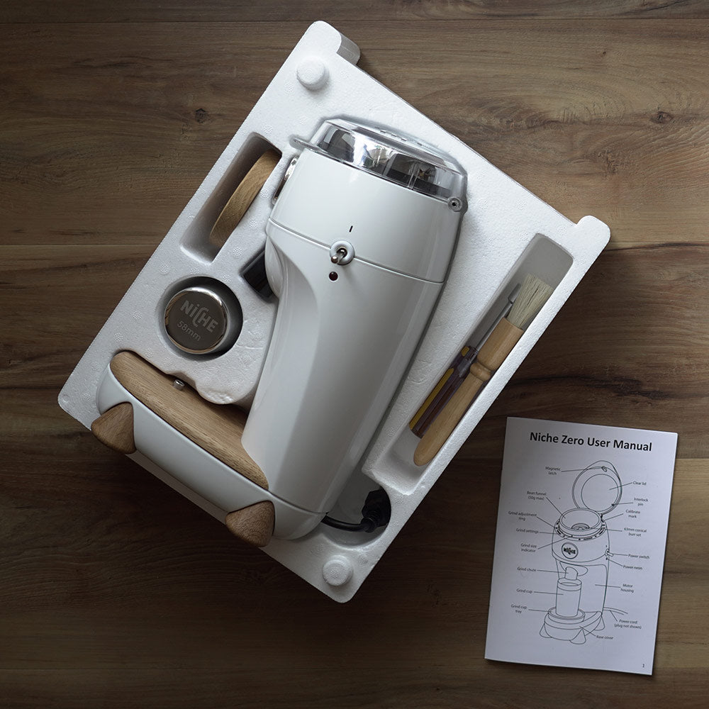 White Niche Zero in packaging next to user manual