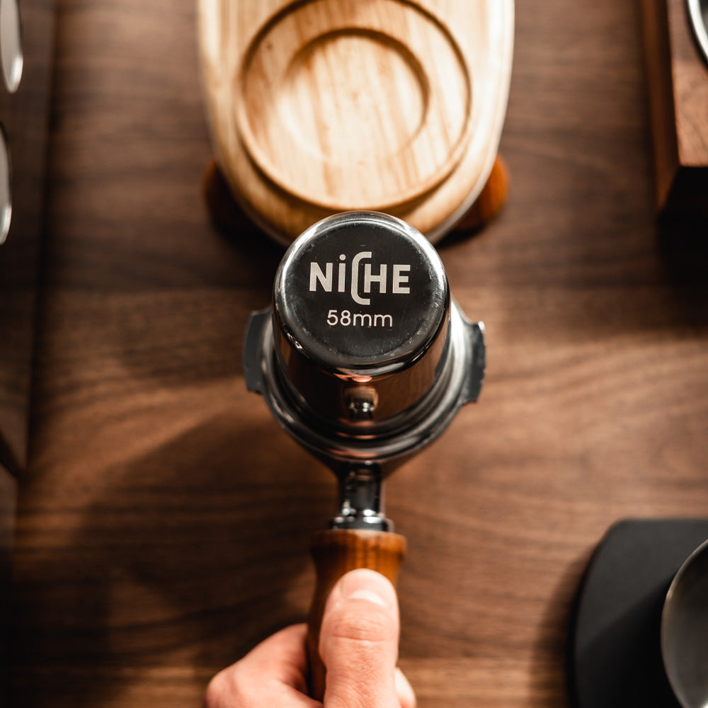 Niche grind cup inverted into portafilter in front of Niche Zero